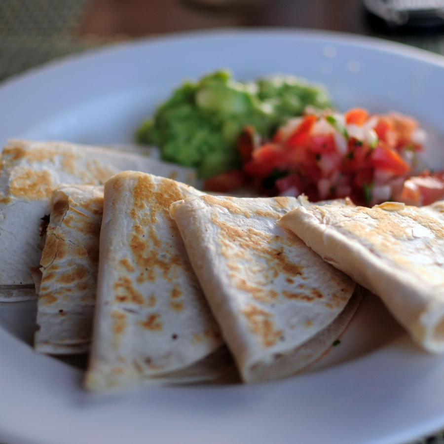 A quesadilla with salsa and guacamole